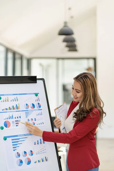 stock image Confident millennial asian businesswoman or female financial analyst explaining company account with her financial information on a board vertical image