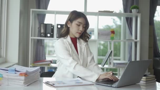 有吸引力的亚洲女商人使用笔记本电脑 用财务报告的计算来核对手头的财务文件 用笔记本电脑和计算器来帮助组织文书工作 — 图库视频影像
