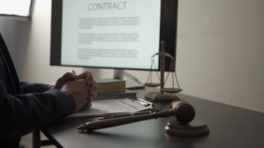 Asyalı erkek avukat, hukuk kitaplarını okumak, çekiç ve teraziyle çalışmak, hukuk danışmanı konsepti.