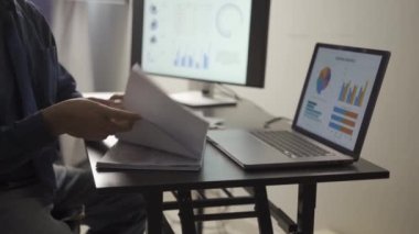 Bilgisayar ekranı ve finansal muhasebe konsepti üzerine gece geç saatlere kadar ofisinde çalışan genç işadamı.