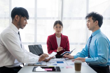 Bir grup başarılı genç iş adamı toplantılarda finansal raporlar sunuyor ve iş stratejilerini analiz etmek ve planlamak için beyin fırtınası fikirleri sunuyorlar..