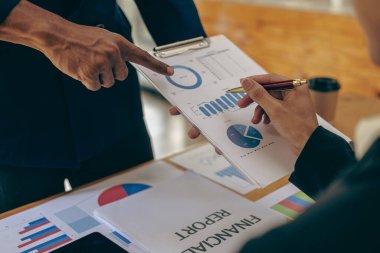 Fon yöneticisi ekibi, konferans odasındaki mali durumu analiz etmek ve tartışmak üzere dijital tablet iş danışmanlarıyla görüşerek borsa analizini ele alır ve tartışır.