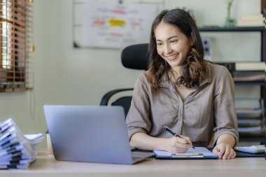 İşte dizüstü bilgisayarında çalışan Asyalı bir kadın finansal rapor planlama iş planı yatırım Finansal iş analizi ve araştırma kavramları.