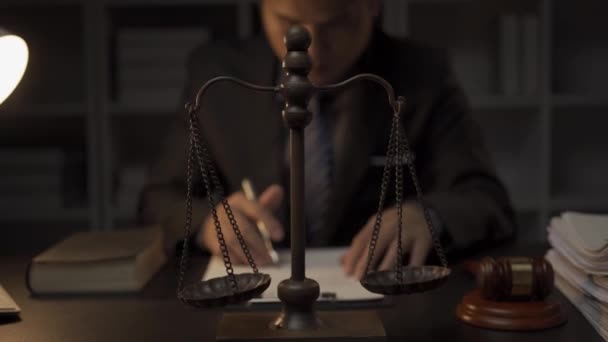 スマートでプロフェッショナルなアジアの男性弁護士は オフィスの夜に机に座って正式なスーツを着ています 弁護士 法律顧問 — ストック動画