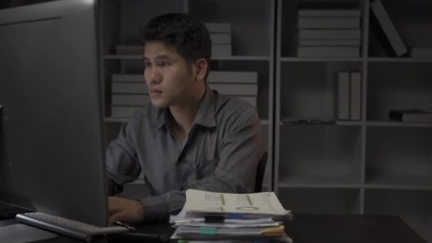 Asyalı Erkek Işadamı Mali Belgelerle Masaüstü Bilgisayarlarıyla Geç Saatlere Kadar — Stok video