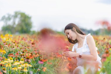 Güzel Asyalı bir kadın güzel renkli çiçeklerle bahçesinde Asyalı bir kadın çiçek bahçesinde dinlenirken, Chiang Mai, Tayland