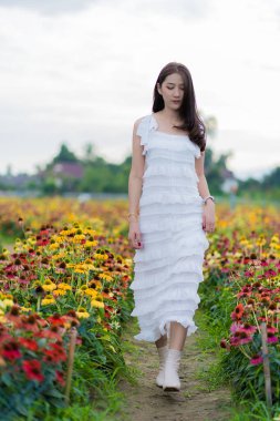 Güzel Asyalı bir kadın güzel renkli çiçeklerle bahçesinde Asyalı bir kadın çiçek bahçesinde dinlenirken, Chiang Mai, Tayland