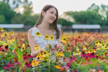 Güzel Asyalı bir kadın güzel renkli çiçeklerle bahçesinde Asyalı bir kadın çiçek bahçesinde dinlenirken, Chiang Mai, Tayland