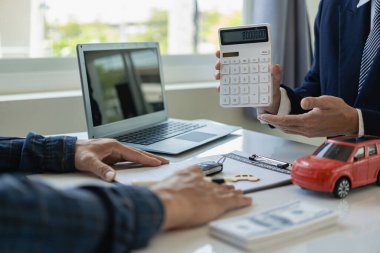 Araba işi, araba satışı, ulaşım, insanlar ve mülkiyet. Yakın çekim, müşteri kontrat imzalar ve ödeme yapar, satış müdürü arabayı satmayı teklif eder ve arabanın durumunu açıklar.