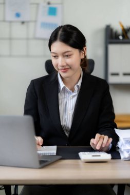 Asyalı bir kadın bilgisayarlı, Asyalı bir iş kadını muhasebeci ile ofisinde oturuyor. dikey resim