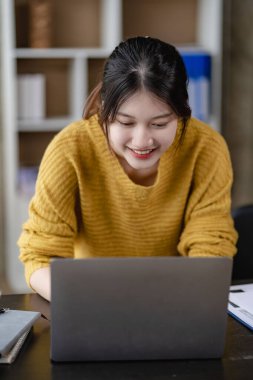 Asyalı kadın ev yapımı KOBİ işi çevrimiçi alışveriş başlayanlar için paket teslimat kutuları hazırlamak için evde küçük işletme sahipleri başlatıyorlar. İnternetten sarı bir kutuyla sipariş edilmiş. dikey resim