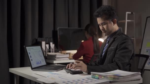 若いアジアのビジネスマン ノートパソコンや財務文書でオフィスで働く男と女性 — ストック動画