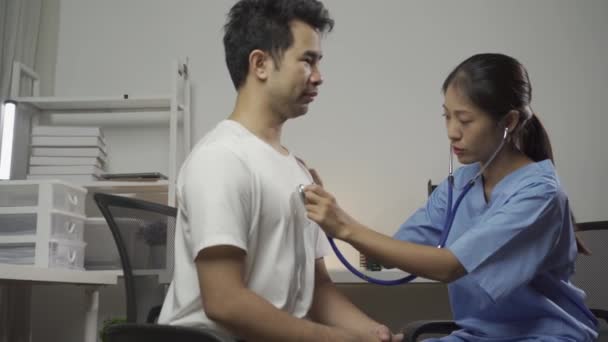 美丽的亚洲医生在检查室测量年轻女性病人的血压 听诊器放在弯道上听心跳声 — 图库视频影像