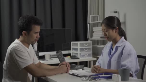 Mannlig Pasient Besøker Asiatisk Kvinnelig Lege Som Diskuterer Helse Medisin – stockvideo