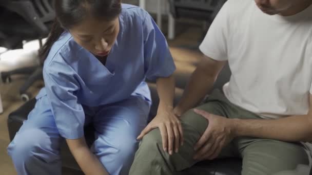 Den Kvinnliga Läkaren Bad Den Manliga Patienten Att Utföra Sjukgymnastik — Stockvideo