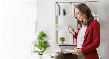 Başarılı iş kadını dizüstü bilgisayarda çalışırken mutlu bir şekilde gülümsüyor. Çevrimiçi zoom muhasebe muhasebe finans kurumları vergisi konferansı yapıyor.