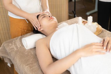 Güzel Asyalı kadın spa ortamında masaj yaptırıyor aroma terapisi güzellik tedavi spa hizmeti sunuyor genç kadın yatakta yatıyor