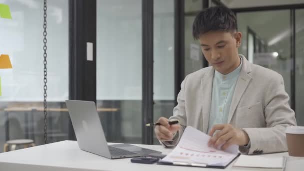 Uśmiechnięty Azjatycki Mężczyzna Księgowy Pracujący Biurku Obliczając Roczny Podatek Papierkowej — Wideo stockowe