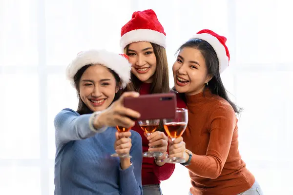 Three Asian girls having fun at a company party Company annual party Alcohol and Pizza Party Celebrate Christmas with champagne and eat pizza at home. The joy of a holiday party with friends