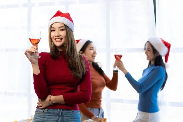 Three Asian girls having fun at a company party Company annual party Alcohol and Pizza Party Celebrate Christmas with champagne and eat pizza at home. The joy of a holiday party with friends