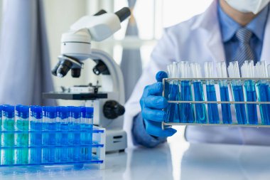 Bilim adamları, mikroskobik laboratuvarı olan bir laboratuvar şişesinde mavi ozon suyuyla bir şişe çivit çözeltisi üzerinde çalıştılar. Doktor Uzak Resim