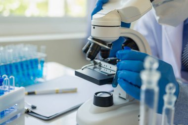 Bilim adamları, mikroskobik laboratuvarı olan bir laboratuvar şişesinde mavi ozon suyuyla bir şişe çivit çözeltisi üzerinde çalıştılar. Doktor Uzak Resim