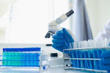 Bilim adamları, mikroskobik laboratuvarı olan bir laboratuvar şişesinde mavi ozon suyuyla bir şişe çivit çözeltisi üzerinde çalıştılar. Doktor Uzak Resim