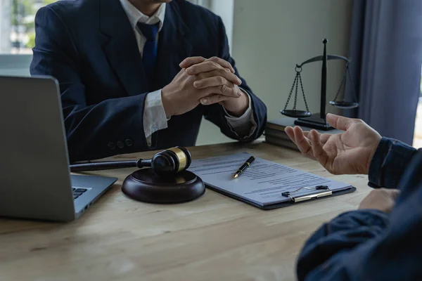 Lawyers consult with clients, discuss contracts. A businessman lawyer discusses and explains the business terms of contracts with clients in law firms.