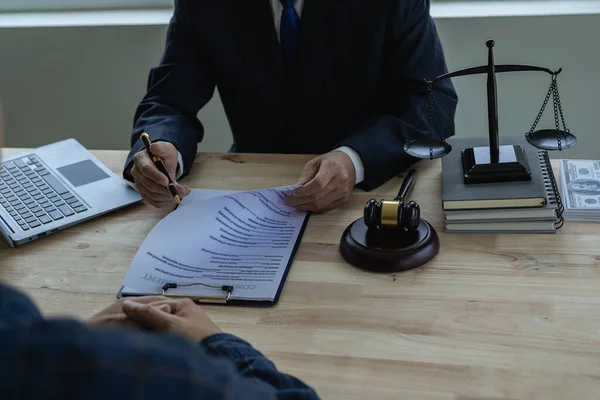 Lawyers consult with clients, discuss contracts. A businessman lawyer discusses and explains the business terms of contracts with clients in law firms.