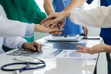 Doktorlar ve hemşireler ellerini birleştirir ve hastanelerde işbirliği yaparlar, birlikte çalışarak sağlık hizmetlerinde ilham ve başarı elde ederler.,