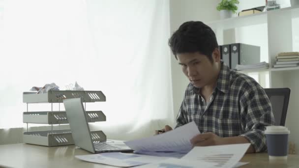 Νεαρός Ασιάτης Επιχειρηματίας Που Εργάζεται Στο Σπίτι Υπολογίζοντας Οικονομικά Στοιχεία — Αρχείο Βίντεο