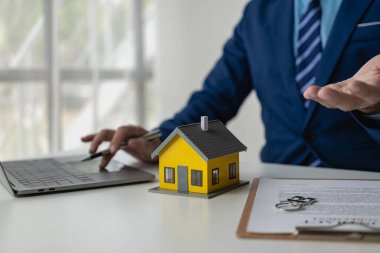Emlakçı ve müşteriyle ev satın alma sözleşmesi, sigorta ya da kredi geçmişini tartışan emlak konsepti. Yakın plan resimler.