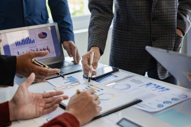 Ofisteki iş adamları ve ofis çalışanlarının grup toplantısı konferans masasında proje planlama belgeleriyle birlikte bir ekip toplantısında çalışıyor. Yakın plan resimler.