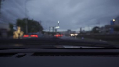 Yağmurlu bir günde, güzel ışıklar ve bokeh ile gece sokaklarda dolaşan bir arabanın içinden çekilmiş bir video..