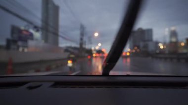 Yağmurlu bir günde, güzel ışıklar ve bokeh ile gece sokaklarda dolaşan bir arabanın içinden çekilmiş bir video..