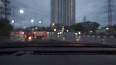 Yağmurlu bir günde, güzel ışıklar ve bokeh ile gece sokaklarda dolaşan bir arabanın içinden çekilmiş bir video..