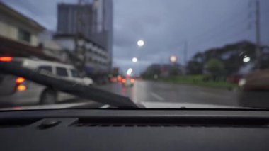 Yağmurlu bir günde, güzel ışıklar ve bokeh ile gece sokaklarda dolaşan bir arabanın içinden çekilmiş bir video..