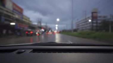 Yağmurlu bir günde, güzel ışıklar ve bokeh ile gece sokaklarda dolaşan bir arabanın içinden çekilmiş bir video..
