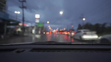 Yağmurlu bir günde, güzel ışıklar ve bokeh ile gece sokaklarda dolaşan bir arabanın içinden çekilmiş bir video..