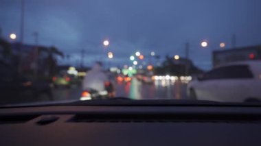 Yağmurlu bir günde, güzel ışıklar ve bokeh ile gece sokaklarda dolaşan bir arabanın içinden çekilmiş bir video..