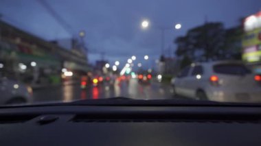 Yağmurlu bir günde, güzel ışıklar ve bokeh ile gece sokaklarda dolaşan bir arabanın içinden çekilmiş bir video..