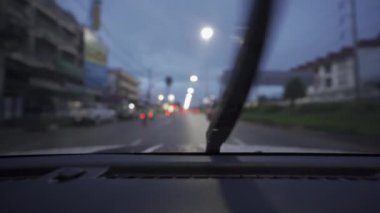 Yağmurlu bir günde, güzel ışıklar ve bokeh ile gece sokaklarda dolaşan bir arabanın içinden çekilmiş bir video..