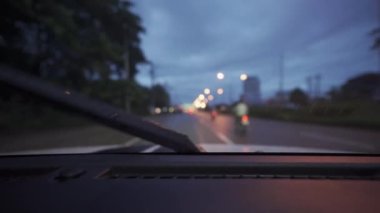 Yağmurlu bir günde, güzel ışıklar ve bokeh ile gece sokaklarda dolaşan bir arabanın içinden çekilmiş bir video..