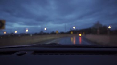 Yağmurlu bir günde, güzel ışıklar ve bokeh ile gece sokaklarda dolaşan bir arabanın içinden çekilmiş bir video..
