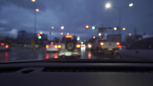 雨の日に車の中から撮影したビデオ 美しいライトとボケで夜の通りをさまよって — ストック動画