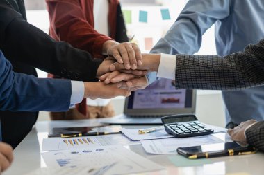 Mutlu iş adamları, ofis masasında mali belgeleri tutan grafik çizelgeleriyle evlenme teklif ederken el sıkışıyorlar. Teklif sözleşmesi. Menajer ve müşteri el sıkışıyor. Yakın plan resimler.