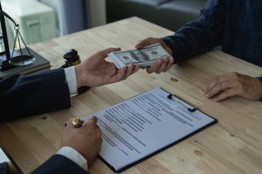 Avukatlar, yetkililer arasında iş ortaklığı anlaşmaları imzalanmadan önce işverenlerden, rüşvetten, yolsuzluktan, operasyonlardan toplanan paralardan para alıyorlar. Yakın plan resimler.