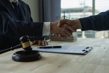 İş adamı, ortak avukatları veya avukatlarıyla anlaşma imzalamak için el sıkışıyor. Anlaşmayı tartışıyorlar. El sıkışan işadamları, avukatlar ve müşteriler, çocuk ve kadınların hak ve özgürlüklerini tartışıyorlar..