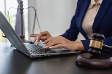 Hukuk bürosundaki yakın plan fotoğraflarda levrek ve teraziyle çalışan kadın avukat.