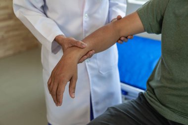 Doktor ya da fizyoterapist kol tedavisi, kas germe ve egzersizleri, ağrı terapisi, rehabilitasyon ve klinikte etkinliği belirlemek için çalışır. Yakın plan resimler.